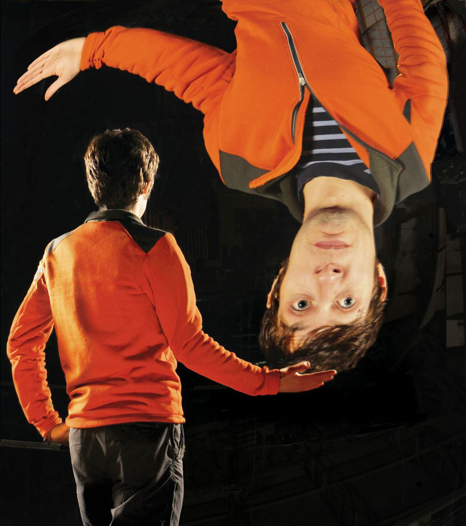 A visitor investigates the reflective properties of the Giant Mirror in the Central Gallery of the Exploratorium